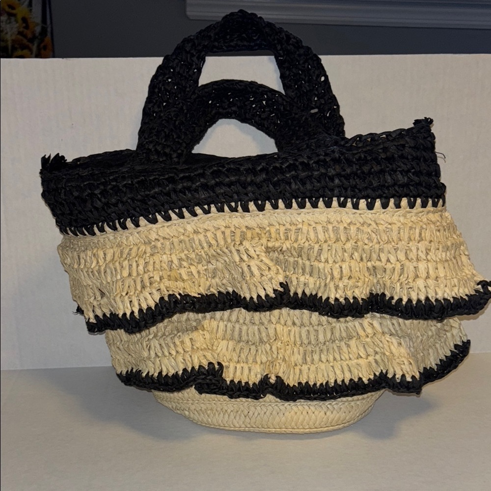PIA ROSSINI..BLACK AND CREAM WOVEN HAND BAG WITH RUFFLES OF STRAW ON ONE SIDE
